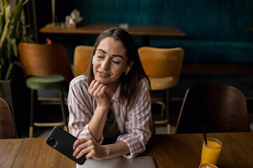 Woman taking a break from work to use her phone in a café