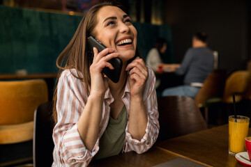Woman talking on the phone in a busy restaurant
