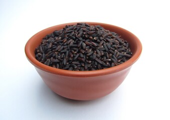 Black rice in a bowl on white background 