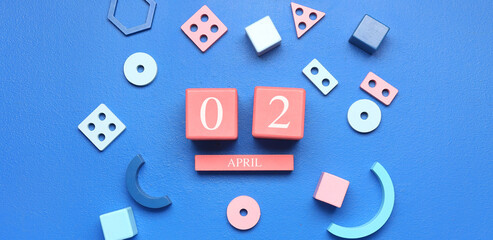 Calendar and toys on blue background. Autism Awareness Day