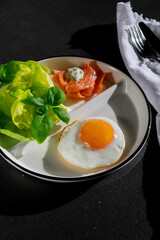 close up of ketogenic breakfast with fried egg, green salad and smoked salmon