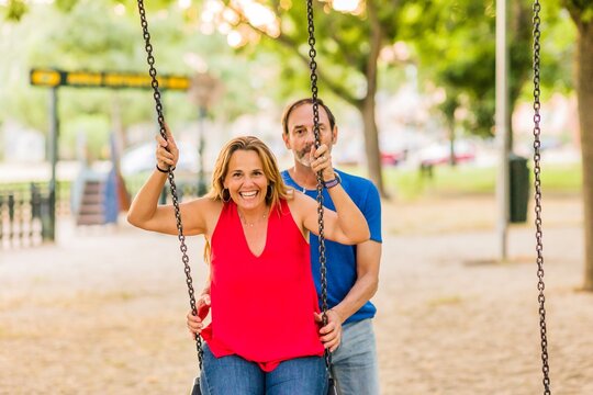 married mature 50s couple enjoy happy in playground swing. Seniors freedom love and happiness - Powered by Adobe