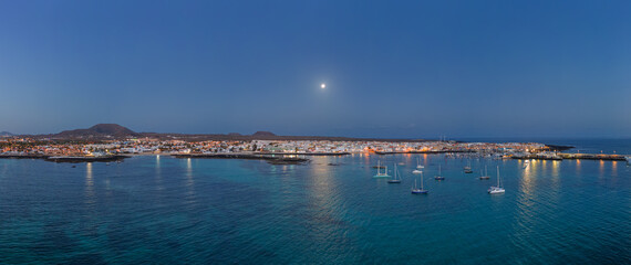Spectacular low aspect panoramic aerial view of the setting moon early morning over Corralejo Fuerteventura Spain