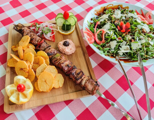 Greek kontosouvli large souvlaki made by fresh meat grilled on fire and served with french fries.