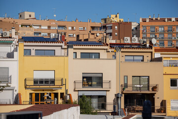 Solar energy panels on the roofs of single-family homes, with balconies and windows, in Barcelona Spain, daytime,. Horizontal