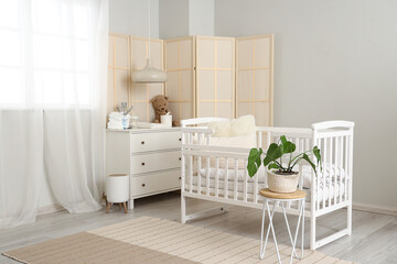 Fototapeta na wymiar Interior of light children's bedroom with crib and commode