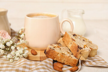 Delicious biscotti cookies, gypsophila flowers and cup of coffee on napkin