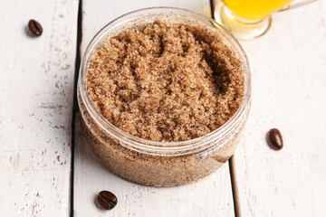 Jar of body scrub on light wooden background, closeup