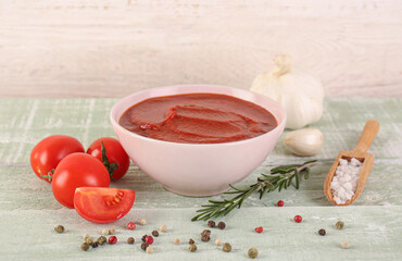 Bowl of tasty tomato paste on wooden background