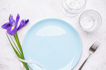 Table setting with beautiful iris flower on grey grunge background