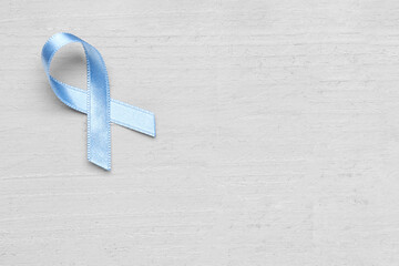 Blue awareness ribbon on light wooden background. Prostate cancer concept