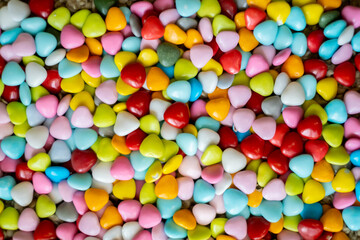Fototapeta na wymiar Mix of colorful candies. Sweet colorful jelly beans as a background. Dragee candy in the shape of a heart. Confectionery.