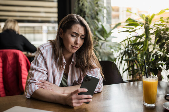 Woman Crying While Looking At Her Phone In A Public Place