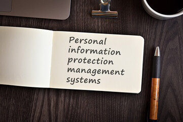 There is a notebook with the word Personal information protection management systems. It is eye-catching image.