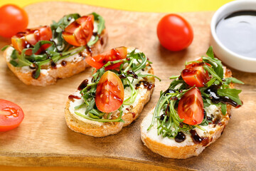 Fototapeta na wymiar Wooden board of tasty sandwiches with cream cheese, arugula and tomatoes, closeup