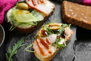 Board with tasty sandwiches, closeup