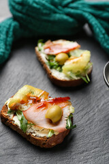 Slate board with delicious sandwiches, closeup