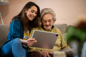 Senior woman receiving virtual medical advice from nurse using digital tablet.