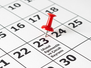 Red pushpin on 23 of April on a calendar