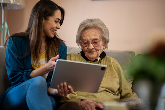 Nurse And Senior Woman Reviewing Medical Records On A Digital Tablet.