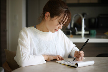 	筆ペンで字を書く女性