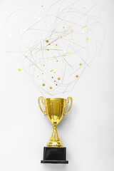 Gold cup with confetti on light background