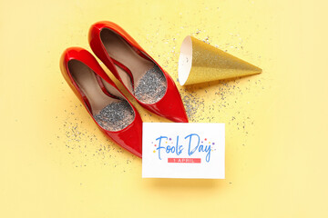 Card for April Fools' Day, heels with confetti and party hat on yellow background