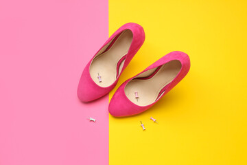 Heels with pins on color background. April Fools' Day celebration