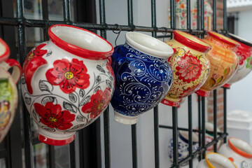 Colorful ceramic pots and dishes with decorations at souvenir shop in Mijas historic old white town...