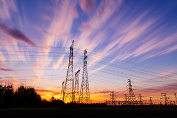 In the evening, the silhouette of high voltage towers