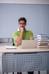 Young male student preparing for exams in the classroom