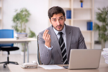Obraz premium Young male employee and too much work in the office