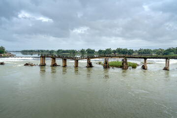 Danger view with damaged bridge across flowing river in rainy season, old broken concrete bridge...