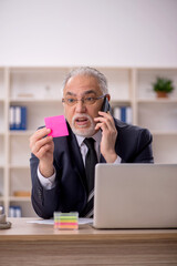 Old male employee working in the office