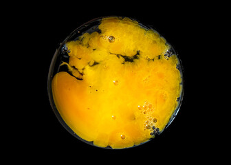 The broken raw egg and scrambled on black background