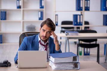 Fototapeta premium Young male employee and too much work in the office