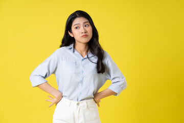 portrait of beautiful asian girl posing on yellow background
