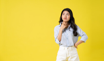 portrait of beautiful asian girl posing on yellow background