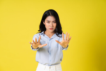 portrait of beautiful asian girl posing on yellow background