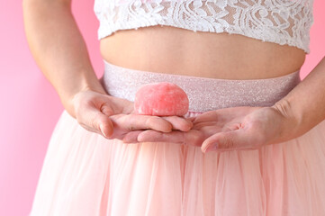 Woman holding in hands pink delicious mochi, closeup. Japanese cuisine, traditional dessert