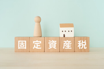 固定資産税と書かれたブロックと人形と家