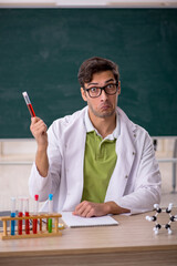 Young male chemist in the classroom