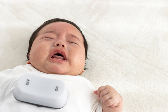 泣く赤ちゃんと玩具のスイッチ(生後3か月、男の子、日本人）。背中スイッチのイメージ
