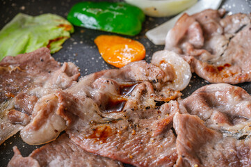 フライパンで焼く薄切り豚ロースと野菜