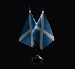 Small national flags of the Scotland on a black background