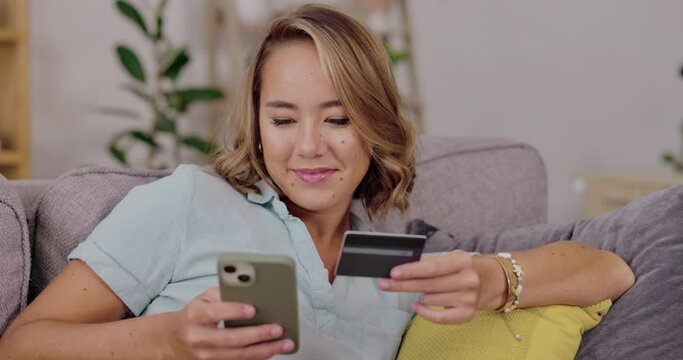 Woman, phone and credit card on sofa for ecommerce, online shopping or internet banking at home. Happy female shopper on smartphone relaxing on living room couch for wireless transaction or purchase