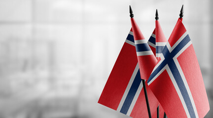 Small flags of the Norway on an abstract blurry background