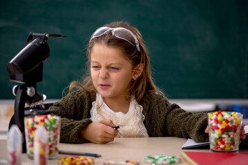 Young little girl chemist in drugs synthesis concept