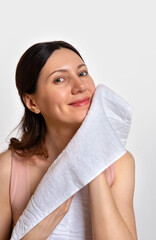 Washing face. Closeup of woman with towel. Beautiful woman wiping facial skin with soft facial towel
