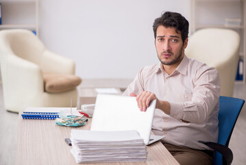 Fototapeta premium Young male accountant working in the office